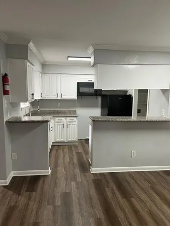 a kitchen with stainless steel appliances granite countertop a stove a microwave a sink and cabinets