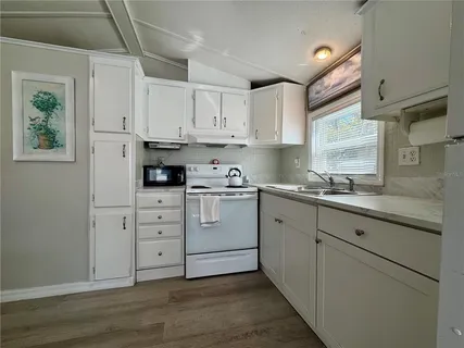 a kitchen with white cabinets and white appliances