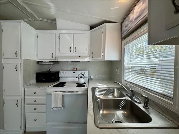 a kitchen with sink a microwave and stove