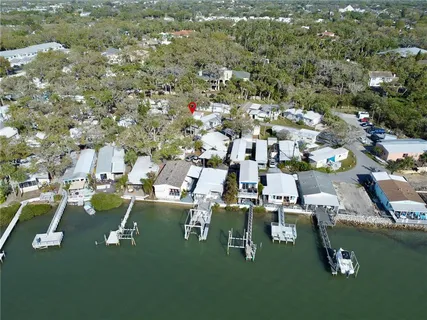 an aerial view of residential houses with outdoor space and trees