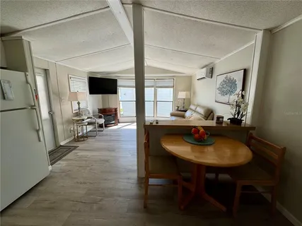 a living room with furniture and a refrigerator