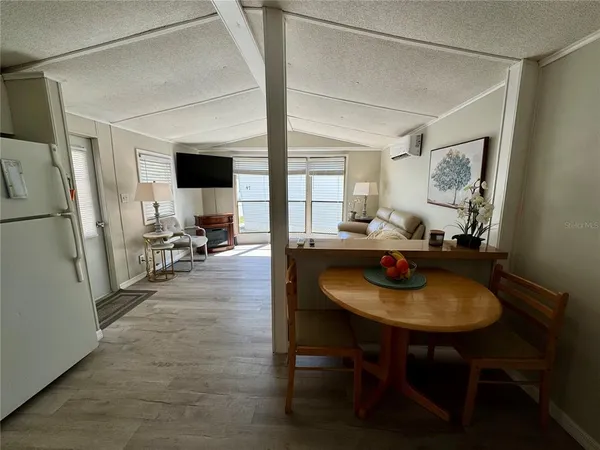 a living room with furniture and a refrigerator