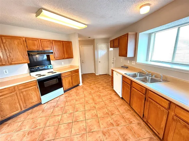 a large kitchen with stainless steel appliances granite countertop a stove and a sink