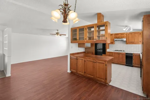 a kitchen with stainless steel appliances granite countertop a stove and a wooden floors