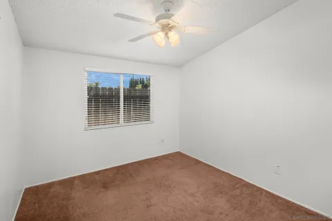 an empty room with a window and a fan