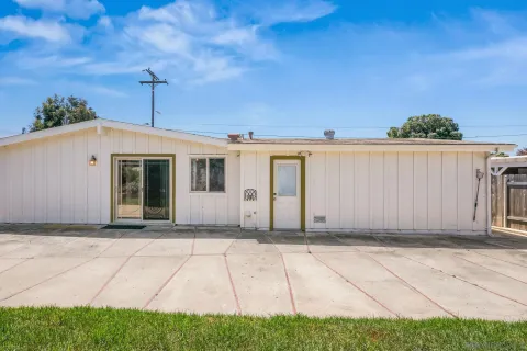 a view of a yard with flower plants and wooden fence