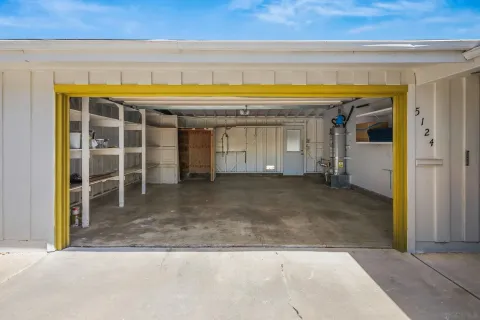 a view of a house with potted plants and a large tree
