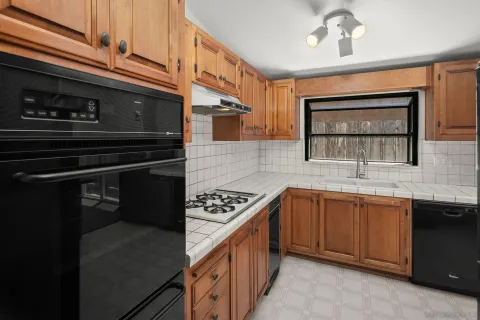 a kitchen with stainless steel appliances granite countertop a sink stove and cabinets