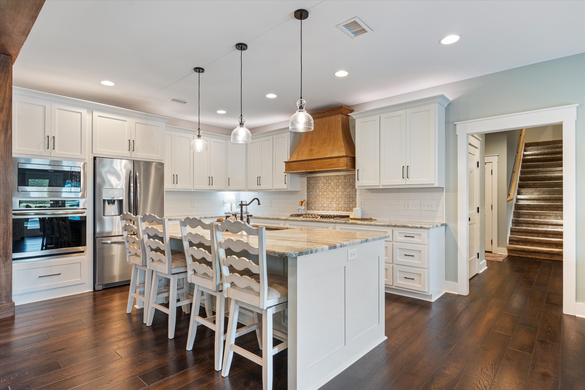 420 Fite Road Watertown, TN 37184 - Photo 32 of 76 a kitchen with stainless steel appliances granite countertop a stove top oven a refrigerator a sink and a dining table with wooden floor