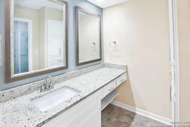 a bathroom with a granite countertop sink and a mirror