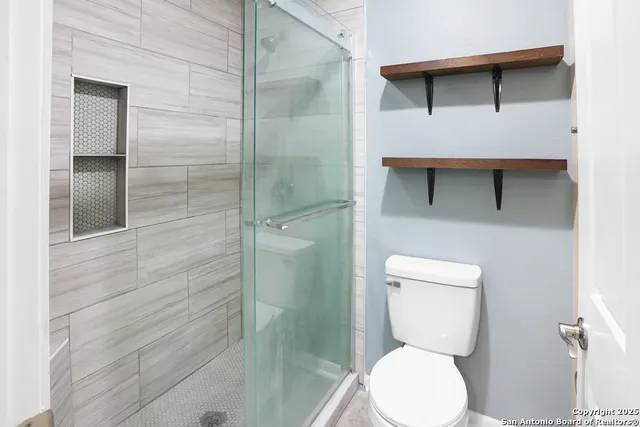 a bathroom with a toilet and a shower