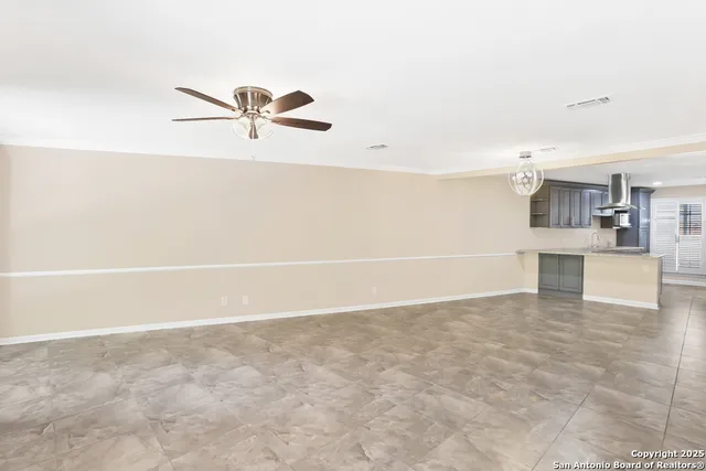 a view of a kitchen with wooden floor and a ceiling fan