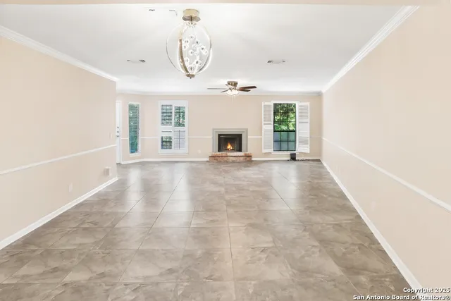 a view of a livingroom with a fireplace a swimming pool and windows