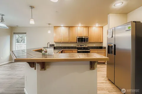 a kitchen with kitchen island stainless steel appliances a sink stove and refrigerator