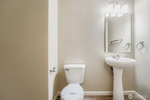 a bathroom with a toilet sink and mirror