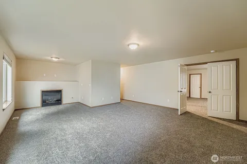 an empty room with a fireplace and window