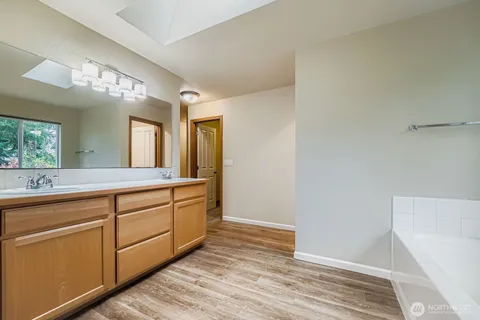 a spacious bathroom with a double vanity sink and a mirror