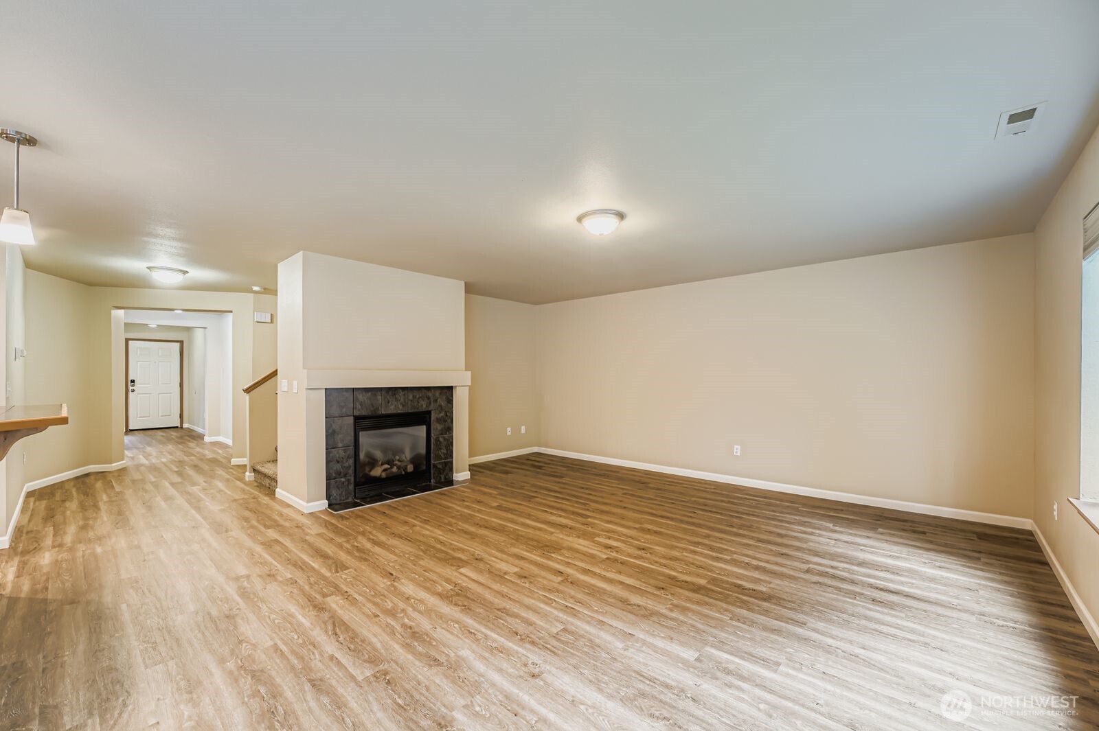 27030 228th Place Southeast Maple Valley, WA 98038 - Photo 5 of 36 an empty room with wooden floor fireplace and windows