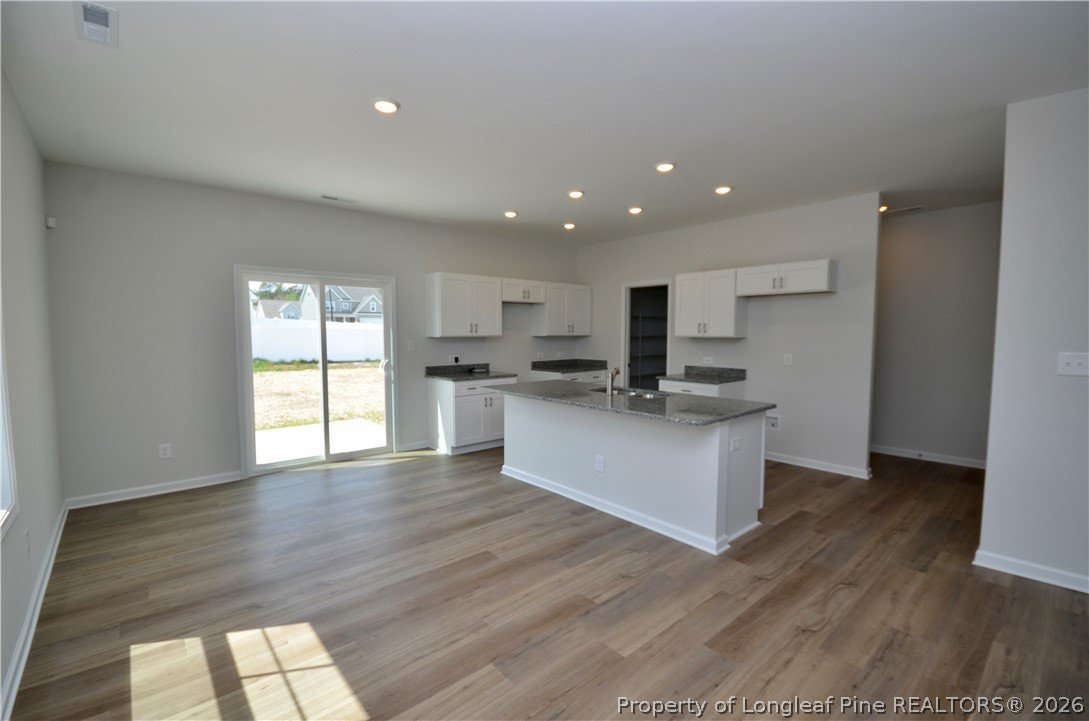 5405 Short Leaf Road Fayetteville, NC 28311 - Photo 5 of 29 a large kitchen with stainless steel appliances granite countertop a large counter top a wooden floor and a sink
