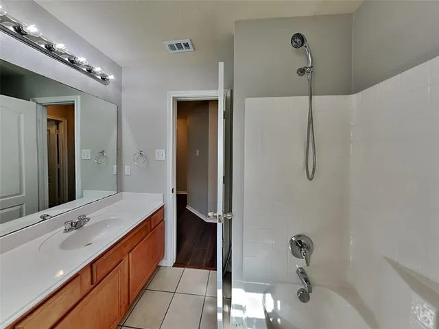 a bathroom with a double vanity sink a large mirror and shower