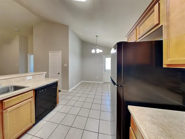 a kitchen with a sink a refrigerator and cabinets