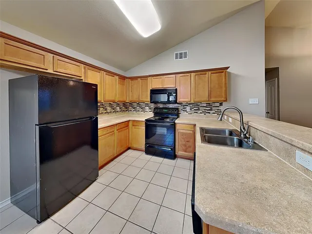 a kitchen with stainless steel appliances granite countertop a refrigerator stove and sink