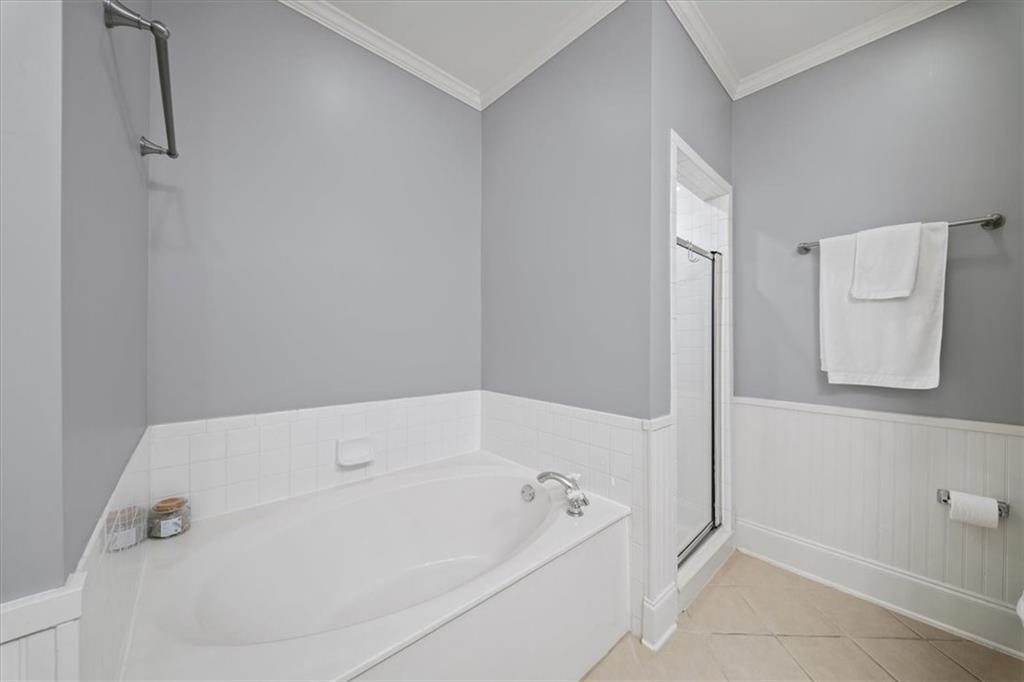4100 Paces Walk Southeast, Unit 1101 Atlanta, GA 30339 - Photo 18 of 36 a bath tub sitting next to a white sink and vanity