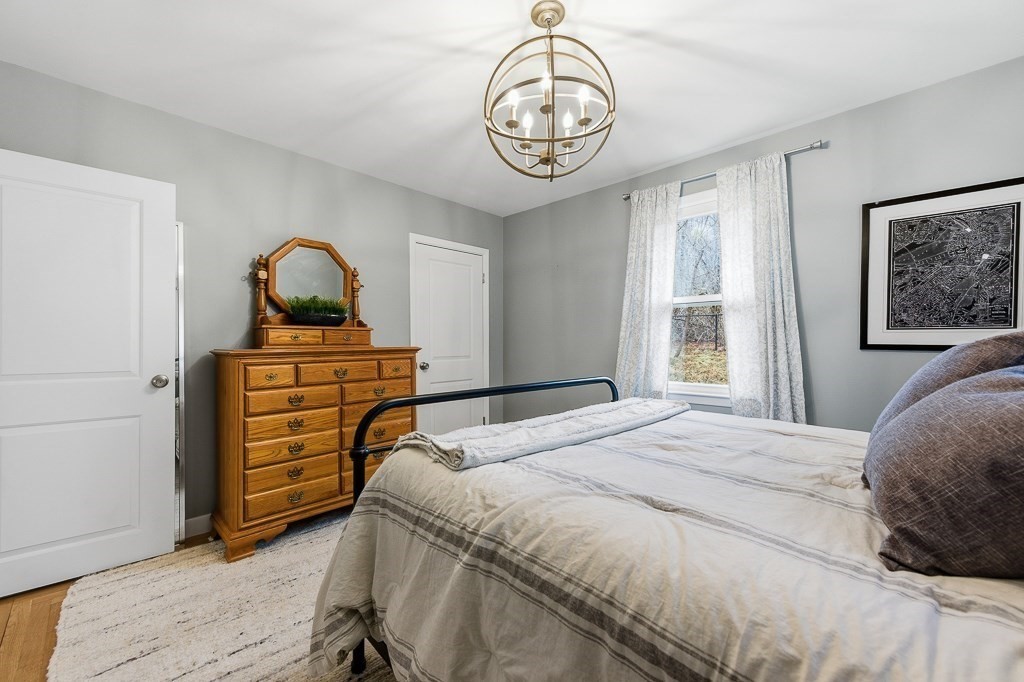 26 Prospect Street Blackstone, MA 01504 - Photo 18 of 41 a bedroom with a bed and a chandelier