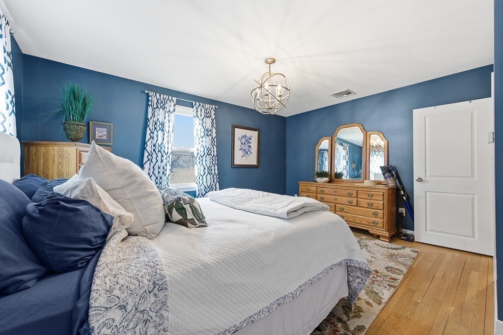 26 Prospect Street Blackstone, MA 01504 - Photo 22 of 41 a bedroom with a large bed and a chandelier