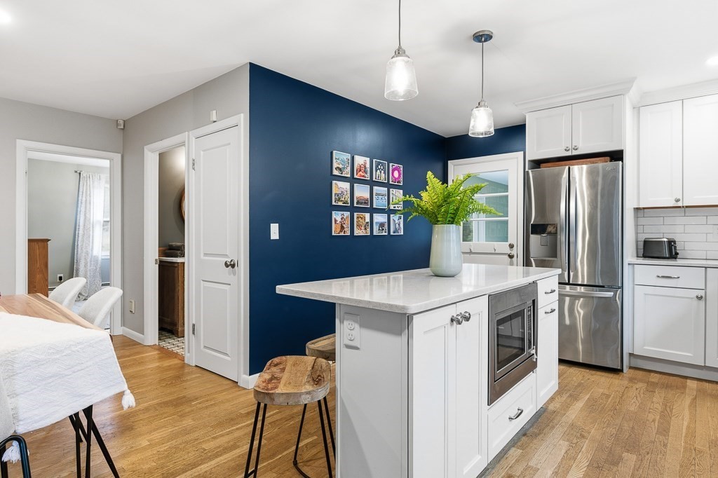 26 Prospect Street Blackstone, MA 01504 - Photo 8 of 41 a kitchen with stainless steel appliances granite countertop a refrigerator a sink dishwasher a stove and a dining table with wooden floor