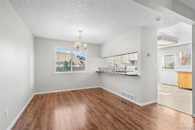a view of kitchen and hall with wooden floor