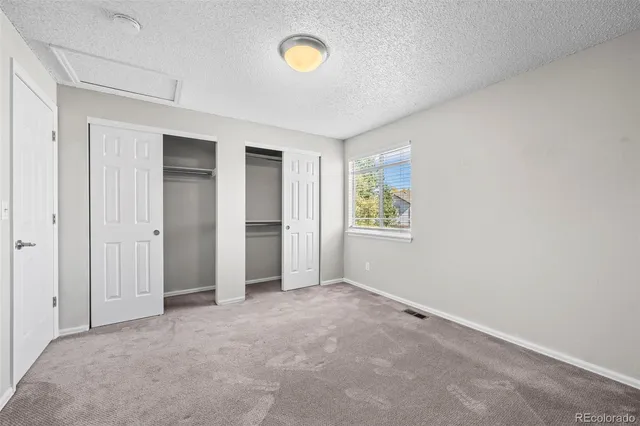 an empty room with windows and closet