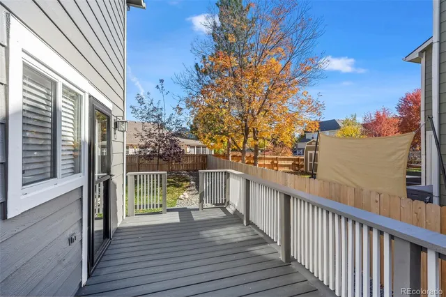 a view of a balcony with wooden floor and fence