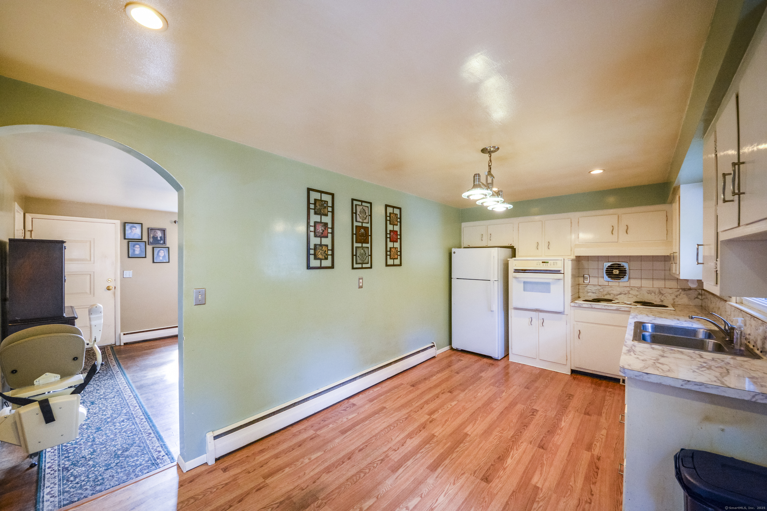 291 Frenchtown Road Bridgeport, CT 06606 - Photo 11 of 40 a open kitchen with a sink dishwasher a dining table and chairs with wooden floor