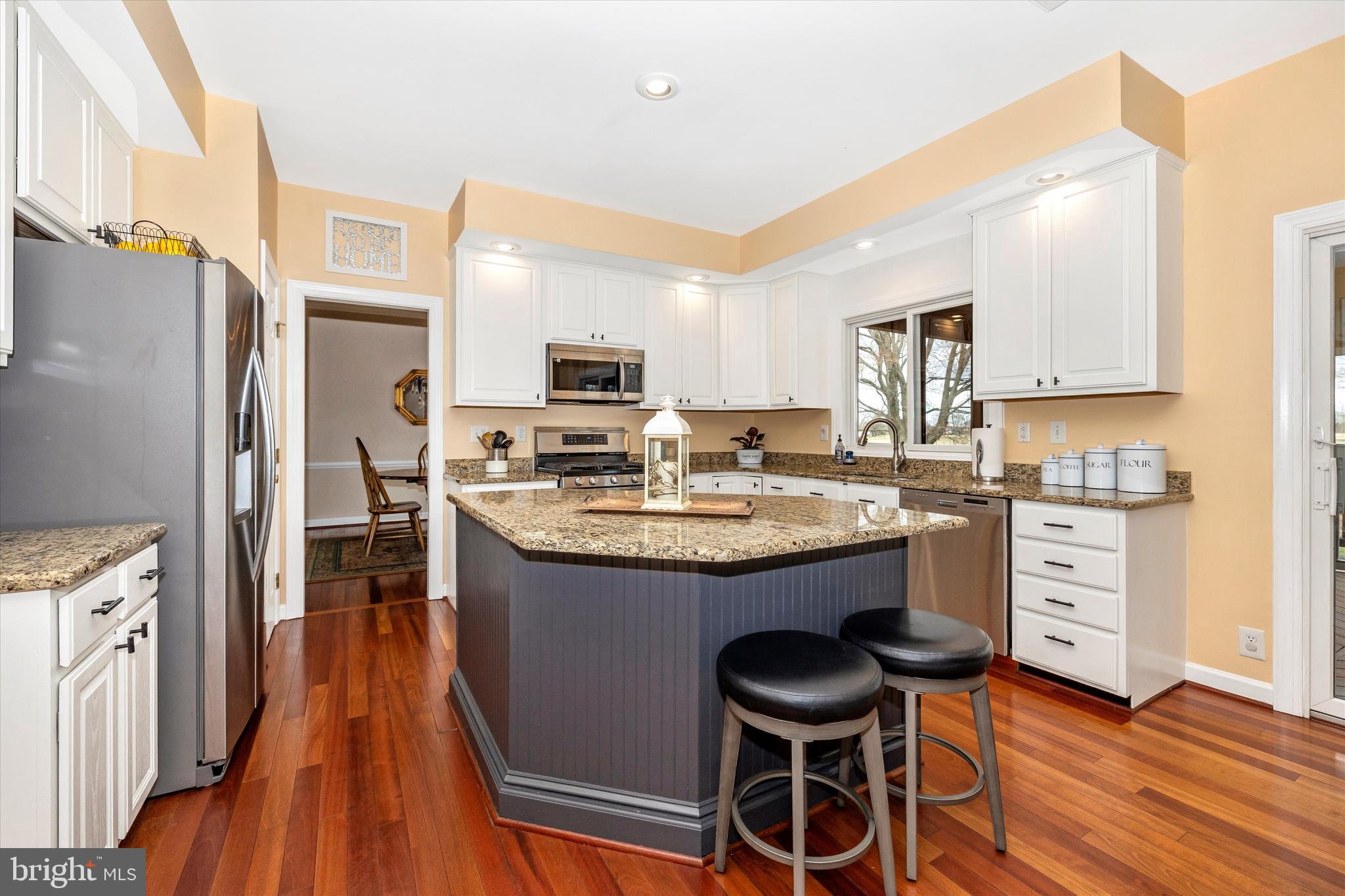 17918 Hickman Street Poolesville, MD 20837 - Photo 11 of 96 a kitchen with granite countertop wooden floors cabinets a sink and appliances