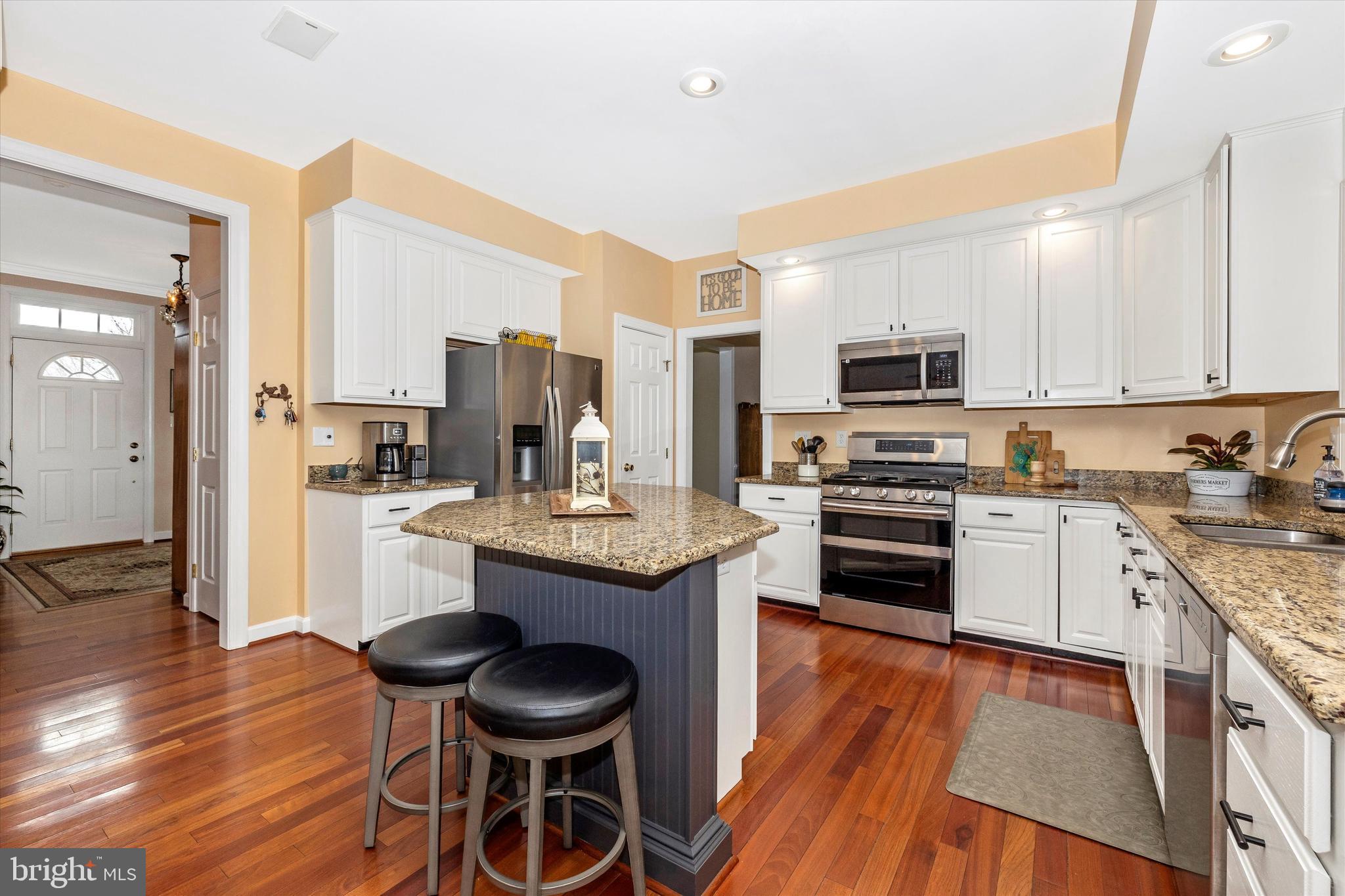 17918 Hickman Street Poolesville, MD 20837 - Photo 12 of 96 a kitchen with granite countertop wooden floors and stainless steel appliances