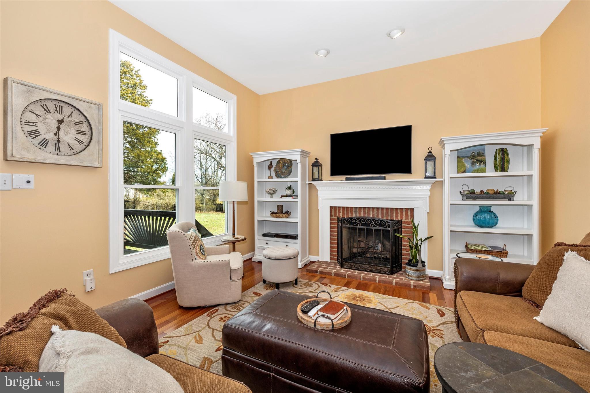 17918 Hickman Street Poolesville, MD 20837 - Photo 19 of 96 a living room with furniture a fireplace and a flat screen tv