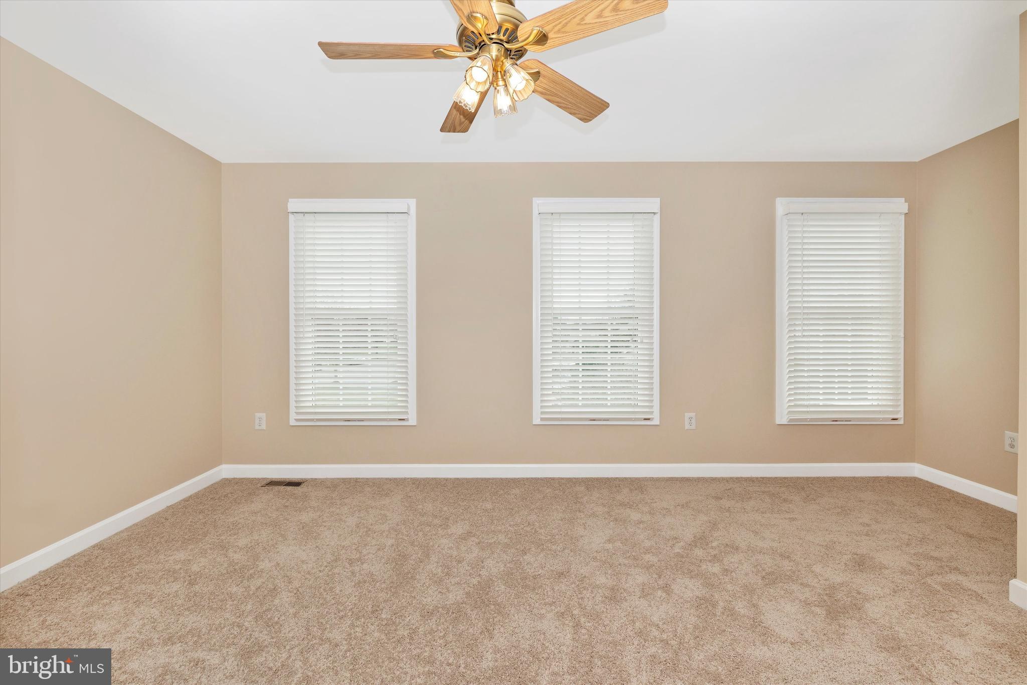 17918 Hickman Street Poolesville, MD 20837 - Photo 33 of 96 an empty room with chandelier fan and windows