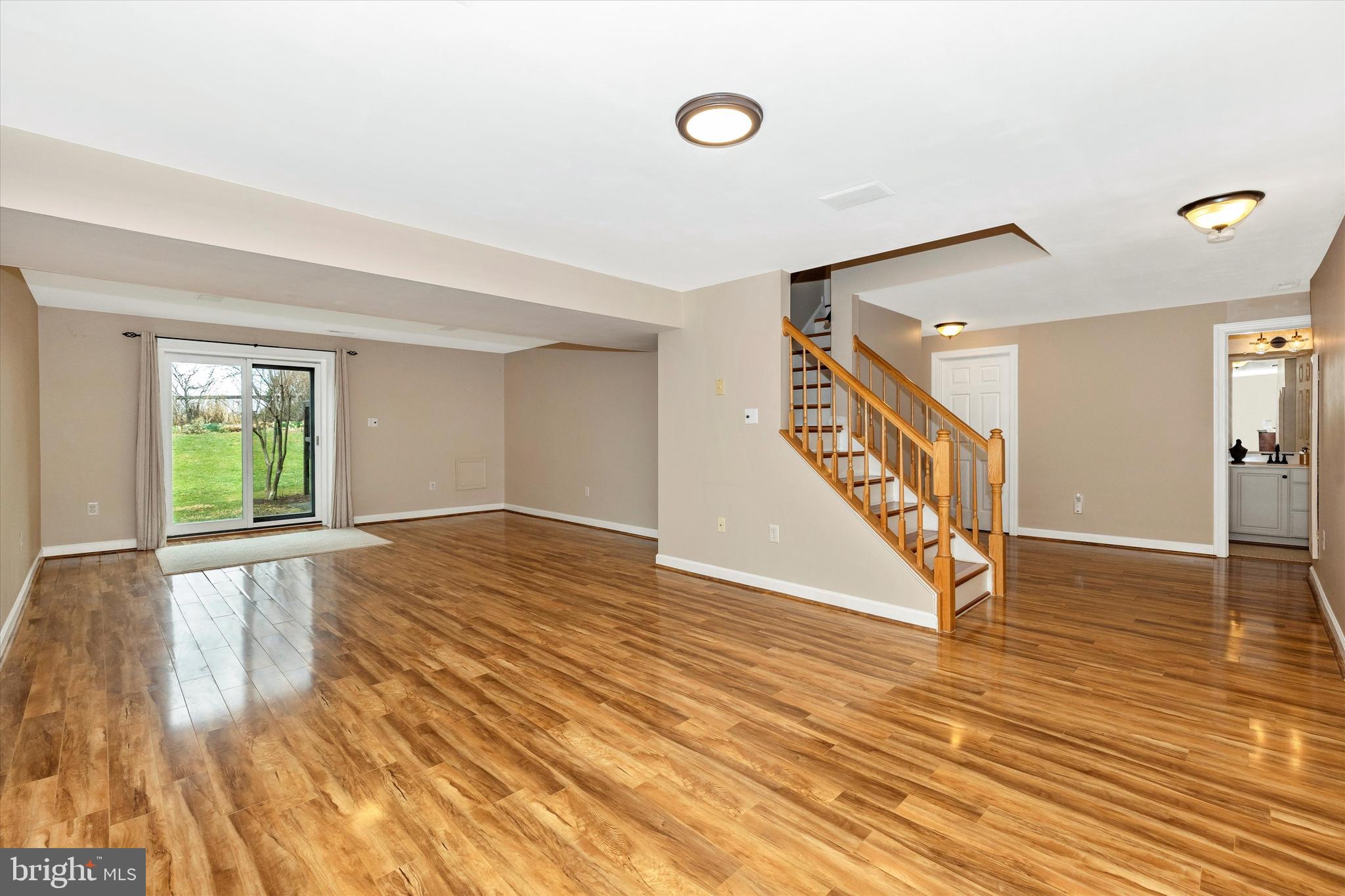 17918 Hickman Street Poolesville, MD 20837 - Photo 41 of 96 a view of an empty room with wooden floor and stairs