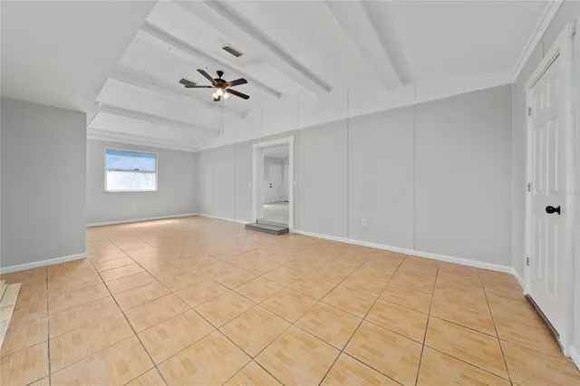 a view of empty room with window and ceiling fan