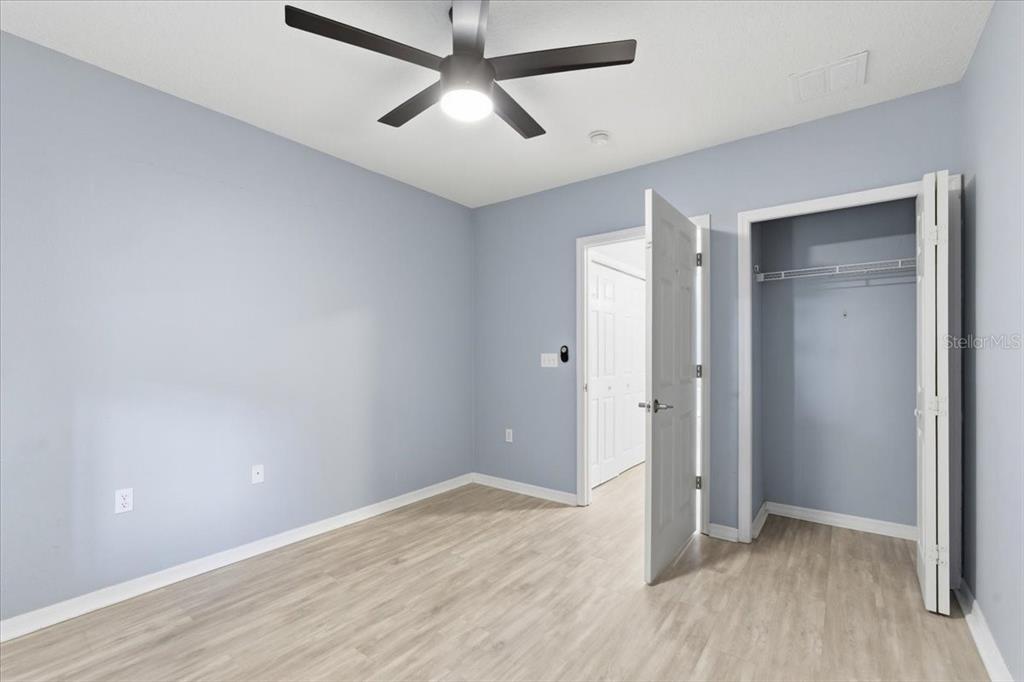 100 Canopy Walk Lane, Unit 112 Palm Coast, FL 32137 - Photo 27 of 62 an empty room with wooden floor and ceiling fan