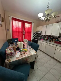 a kitchen with a stove a sink a refrigerator dining table and chairs
