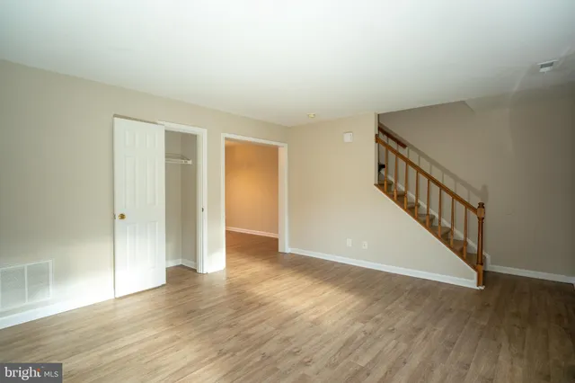 a view of an empty room with wooden floor