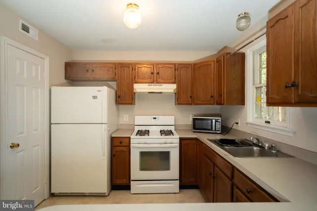 a kitchen with a white cabinets and white appliances
