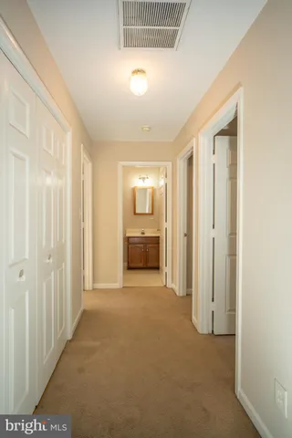 a view of a hallway with an entryway and livingroom
