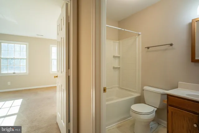 a bathroom with a granite countertop toilet a sink and shower