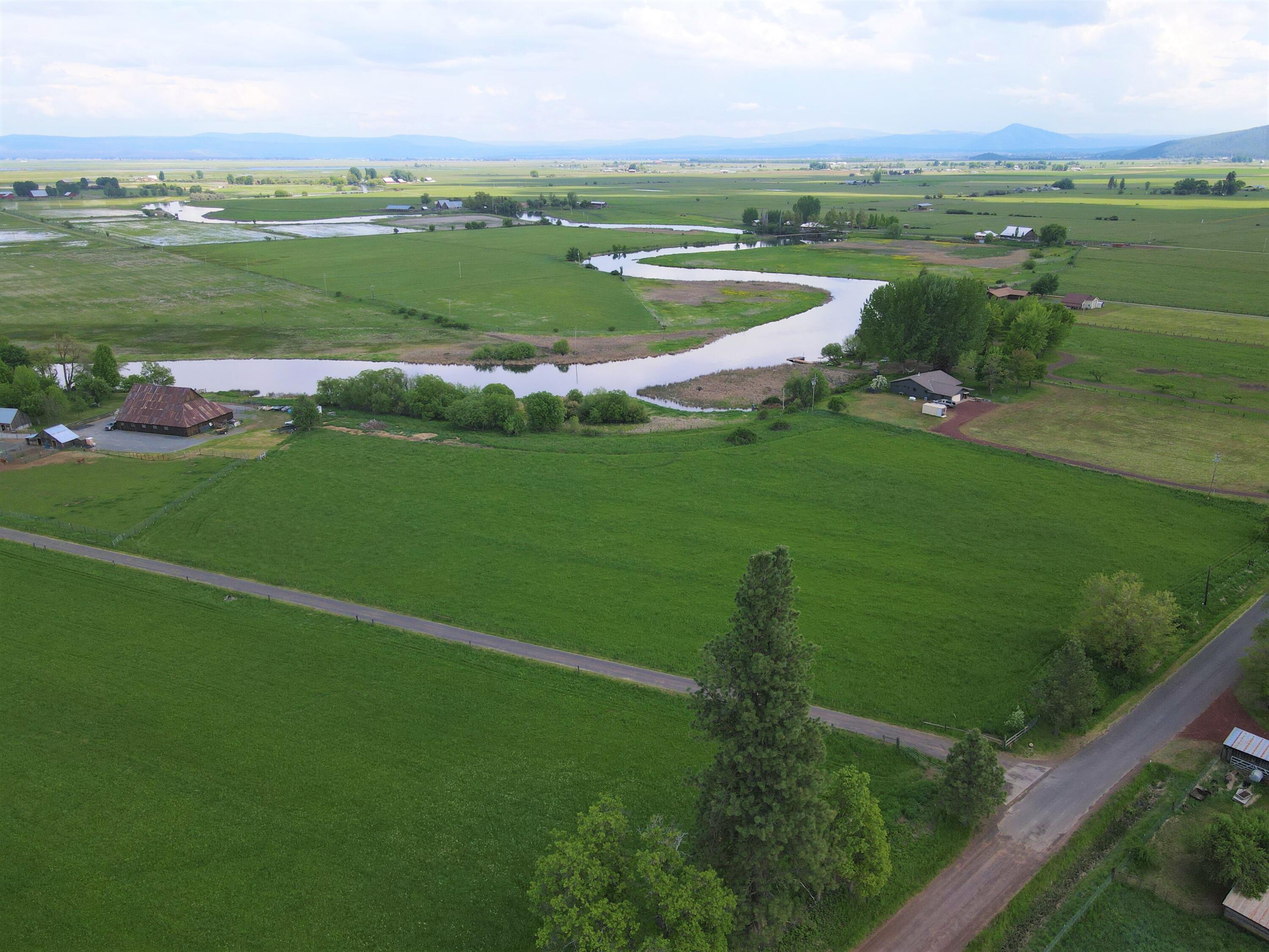 0 Spring Creek Road Fall River Mills, CA 96028 - Photo 2 of 18 a view of a green field with houses in the background