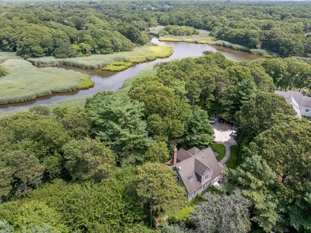 an aerial view of a house with a yard and lake view