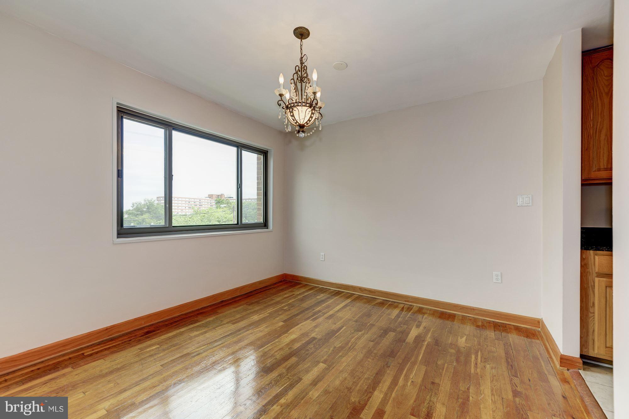 1300 South Arlington Ridge Road, Unit 508 Arlington, VA 22202 - Photo 13 of 24 a view of an empty room with chandelier and wooden floor