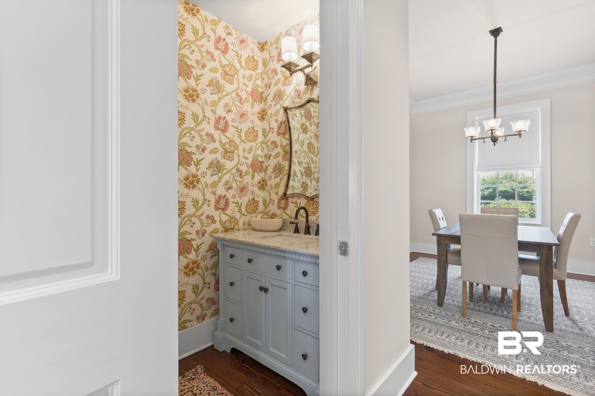 701 Dauphin Street, Unit A Mobile, AL 36602 - Photo 10 of 31 Powder room featuring botanical wallpaper, a light blue vanity with a stone countertop, and a vessel sink